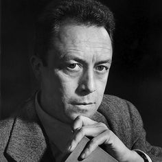 a black and white photo of a man holding a book