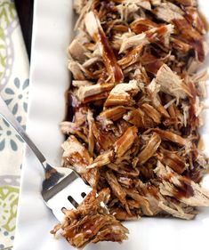 shredded meat on a white plate with a fork