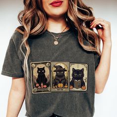 🔮 Unleash Your Feline Fortune with the Black Cat Tarot Shirt! 🔮 Cast a spell on your style this Halloween with our bewitching Witchy Shirt, adorned with not one, not two, but three mystically mischievous black cat tarot cards! Embrace the vintage fall vibes and add a dash of spooky sophistication to your wardrobe. Don't let your chance to be the Cat's Meow this Halloween slip away! Be the first to snatch this Spooky Tee and become the ultimate fashion sorceress in your coven. So, whiskers or n Spooky Black T-shirt With Cat Print, Black Halloween T-shirt With Cat Design, Halloween Black T-shirt With Cat Design, Spooky Halloween T-shirt With Cat Design, Spooky Cat Print Crew Neck T-shirt, Spooky Black T-shirt With Cat Design, Halloween Cat Print Graphic Tee, Halloween Cat Print Crew Neck Top, Halloween Cat Print Crew Neck T-shirt