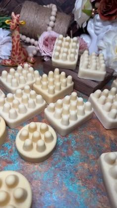 some white plastic pieces on a table with flowers