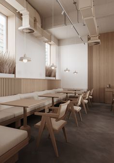 an empty restaurant with wooden tables and white benches in front of large windows on the wall