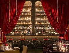 the interior of a restaurant with red curtains