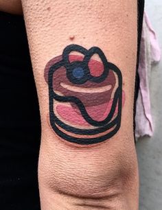 a woman's arm with a cake tattoo on the left side of her body