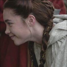 a woman with braids is smiling at something