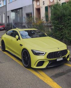 a yellow mercedes cla parked on the street