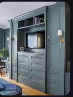 a living room filled with furniture and a flat screen tv on top of a wooden cabinet