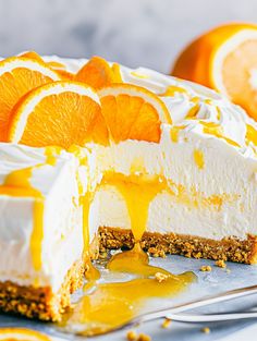 a cheesecake with oranges on the side and one slice cut out from it