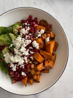 a white bowl filled with vegetables and feta cheese