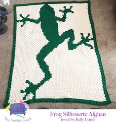 a crocheted rug with a green frog on it's back and the words frog silhouette afghan written below