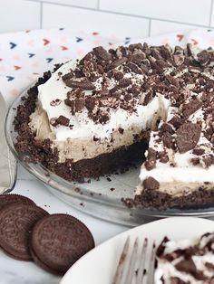 a chocolate oreo cookie cake on a plate with a slice taken out of it