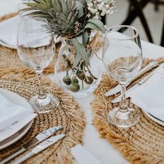 the table is set with silverware and flowers in glass vases on top of burlap place mats