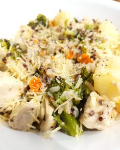 a white plate topped with chicken and broccoli covered in grated parmesan cheese