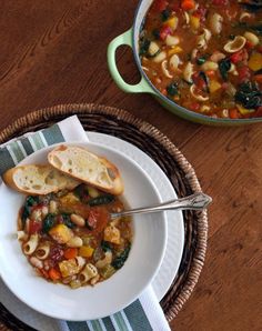 a bowl of soup with bread on the side