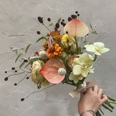 a person holding a bouquet of flowers in their hand