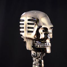 a silver skull with a microphone attached to it's head is shown in front of a black background