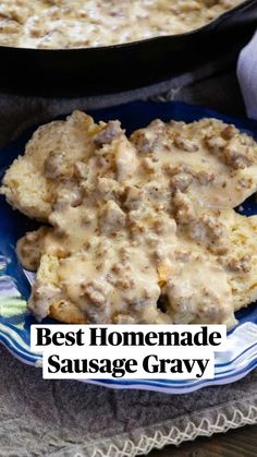 biscuits and gravy on a blue plate with a skillet in the background