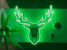 a green neon sign with a deer's head and antlers on the wall