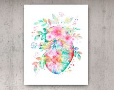 a watercolor heart with flowers and leaves on it is shown in front of a white background