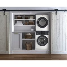 a washer and dryer sitting in front of an open closet with white doors