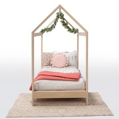 a bed with a pink pillow on top of it and a wooden frame around the headboard