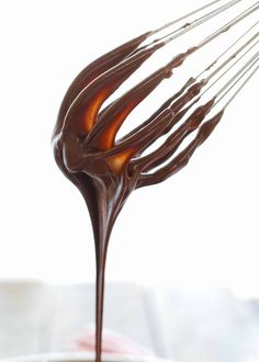 melted chocolate being poured into a bowl with whisk attachments in it's center