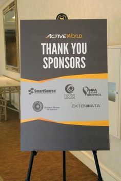 a sign that says,'active world thank you sponsors'in front of a room with tables and chairs