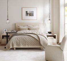 a bedroom with a bed, chair and table next to a window in the room