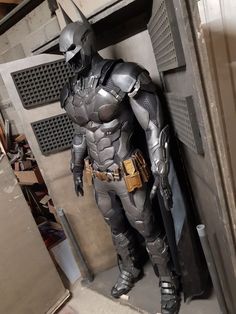 a man dressed as batman standing in front of a door