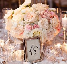 a centerpiece with flowers and candles is displayed at the head table for an elegant wedding reception