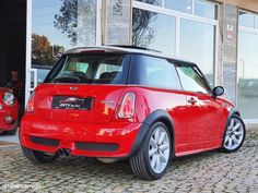 a small red car parked in front of a building