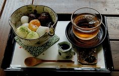 there is a tray with two cups and spoons on it that have food in them