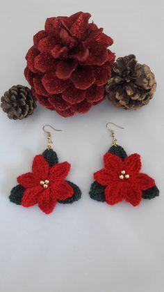 crocheted poinsettia earrings with pine cones on the side and red flower in center