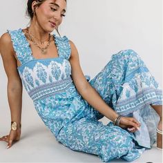 Get Ready To Turn Heads In This Stunning Jumpsuit! Featuring A Trendy Square Neckline And A Smocked Bodice, This Light Blue Boho Print Piece Is Perfect For Any Occasion. The Wide Shoulder Straps And Ruffle Detailing Add The Perfect Touch Of Femininity To This Breezy, Wide-Leg Jumpsuit. Square Neckline Wide Shoulder Straps Smocked Bodice Wide Ruffle Jumpsuit Light Blue Boho Print 100% Polyester Small - Bust: 26”, Waist: 26”, Hip: 38”, Inseam: 26.5” Beach One-piece Jumpsuits And Rompers With Ruffles, Beach One-piece Jumpsuit With Ruffles, Cotton Jumpsuits And Rompers With Smocked Bodice For Vacation, Sleeveless Cotton Jumpsuit With Smocked Bodice, Cotton Sleeveless Jumpsuits And Rompers With Smocked Bodice, Light Blue Sleeveless Romper For Vacation, Blue Bohemian Jumpsuits And Rompers For Beach Season, Bohemian Blue Jumpsuits And Rompers For Beach Season, Blue Jumpsuit With Smocked Back