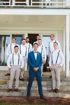 a group of men standing next to each other in front of a house