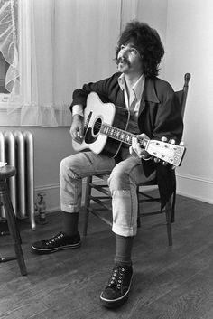 a man sitting in a chair holding a guitar