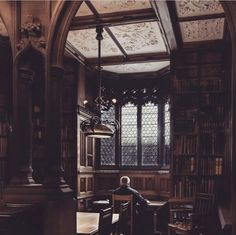 a man sitting at a table in an old library