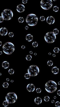 soap bubbles floating in the air on a black background