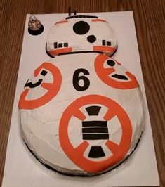 a star wars themed cake is displayed on a white sheet with orange and black decorations