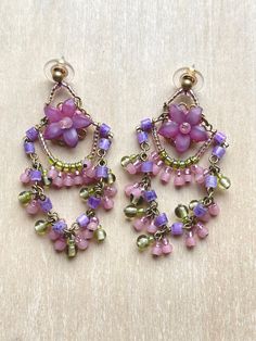 two pairs of earrings with flowers and pearls hanging from the end of each earring