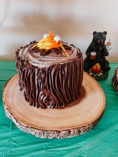 a chocolate cake sitting on top of a wooden table next to a bear figurine