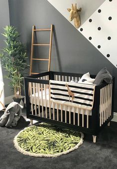 a black and white baby crib with green bananas on the floor next to a ladder