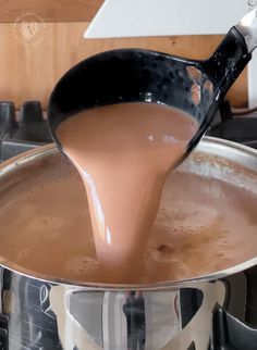 a sauce being poured into a pot on the stove