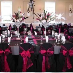 the table is set up with black and pink decorations