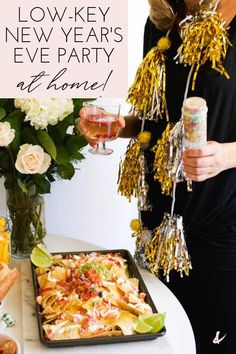 a woman standing in front of a tray of food and drinks with the words low key new year's eve party at home