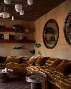 a living room filled with lots of furniture next to two round mirrors on the wall