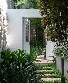 an open door leading into a lush green garden