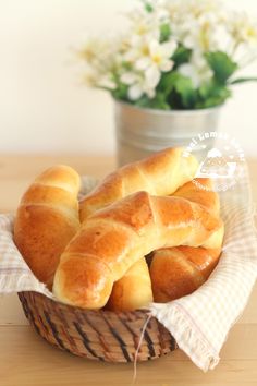 a basket filled with croissants sitting on top of a wooden table