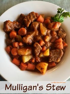 a white plate topped with meat and veggies on top of a blue table cloth