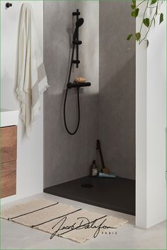 a bathroom with a black shower head and hand held shower faucet in it