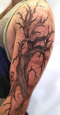 a man with a tree tattoo on his arm and shoulder is shown in this image